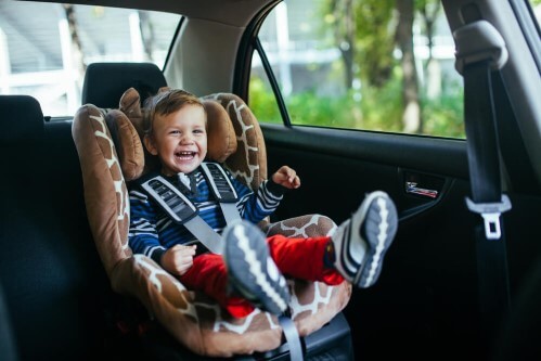 ילד מחייך בכיסא בטיחות ברכב