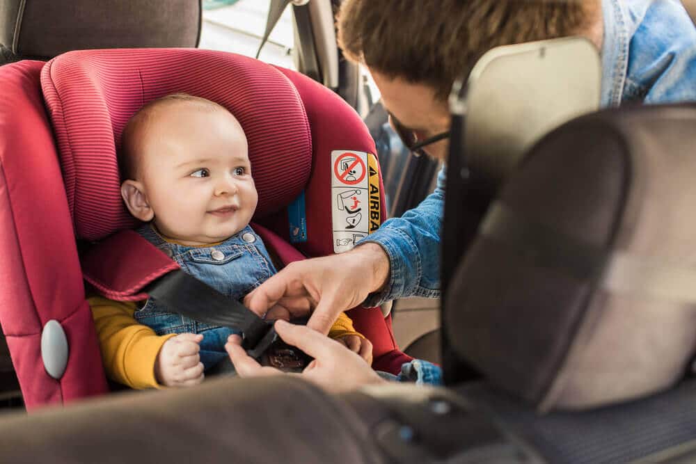 תינוק יושב במושב בטיחות עם התקן איוזפיקס